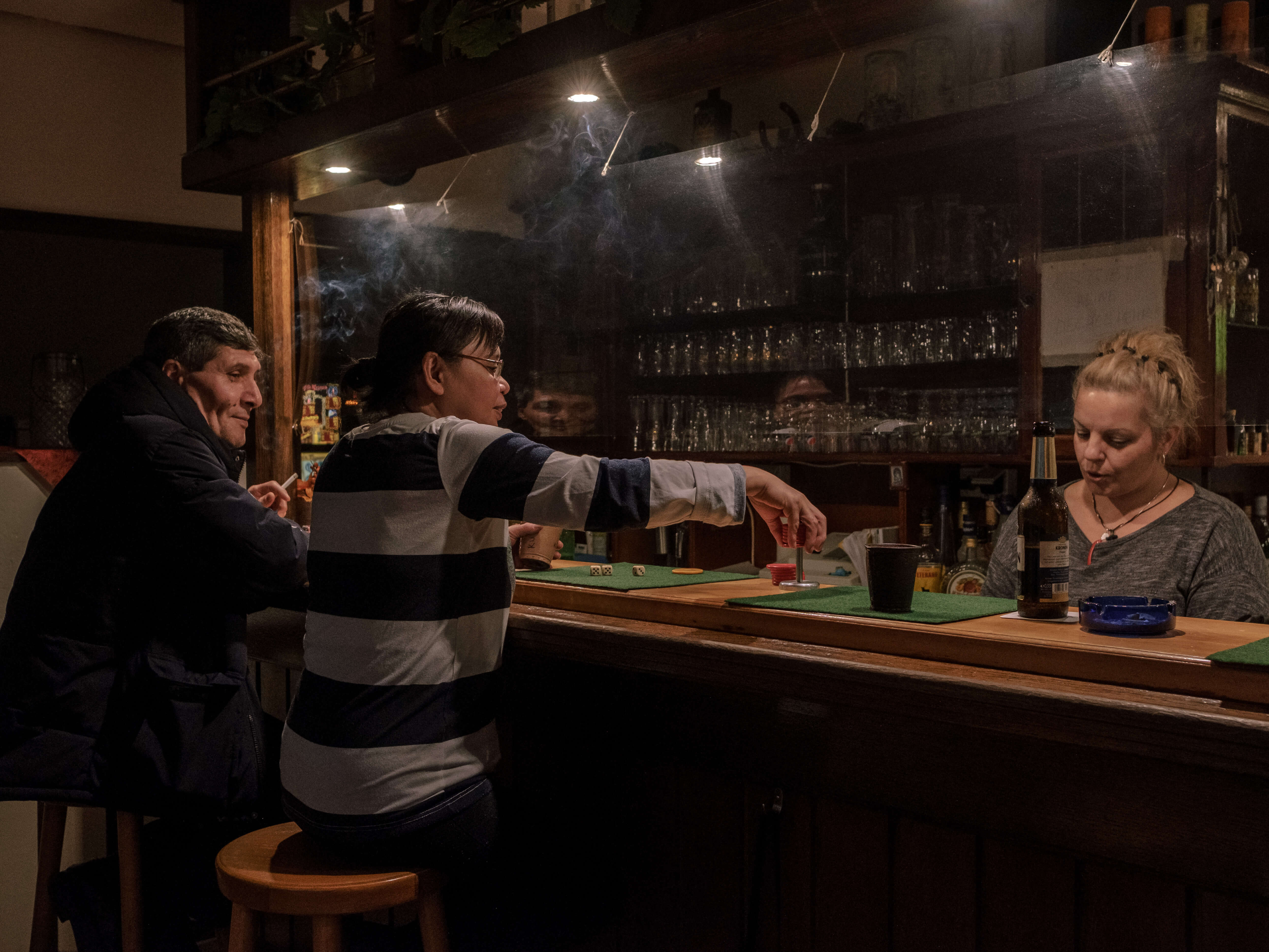 Eine Runde 'Schocken' im Scheffelchen, einer typischen Eckkneipe in Dortmund. Das Spiel ist ein klassisches Trinkspiel bei der es je nach Region eigene Regeln gibt. Früher galt das 'Gasthaus' als Treffpunkt für Arbeiter*innen und Ort der Unterhaltung und des Austausches nach der harten Arbeit. // A round of 'Schocken' at Scheffelchen, a typical corner pub in Dortmund. The game is a classic drinking game with its own rules depending on the region. In the past, the 'Gasthaus' was considered a meeting place for workers and a place for entertainment and exchange after hard work.